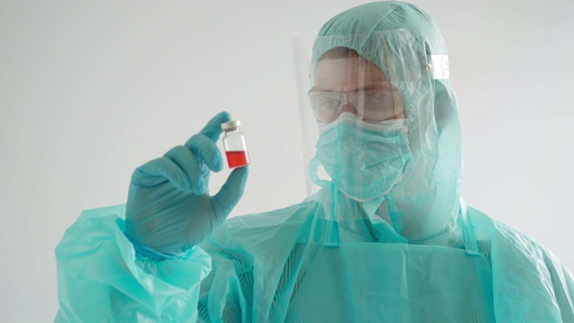 药物开发过程中，医生穿着防护服拿着安瓿视频素材