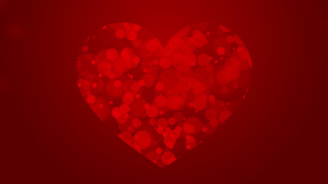 红色的移动粒子形成心形的象征，抽象的爱情主题在黑暗的背景上视频下载