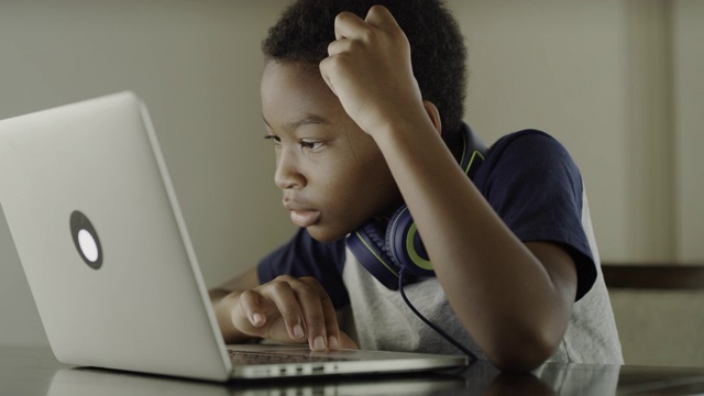 近距离观察在美国犹他州使用笔记本电脑的困惑男孩视频素材
