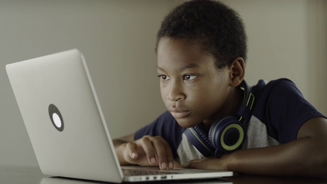 特写严肃的男孩使用笔记本电脑/ Orem，犹他州，美国视频素材