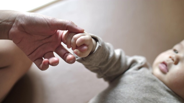 在幼儿园里，抱着妈妈的儿子时，他抓着妈妈的手指视频下载