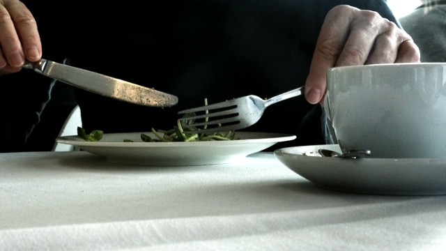 女人吃着向日葵芽沙拉放在桌上的白色盘子里。4 k视频下载