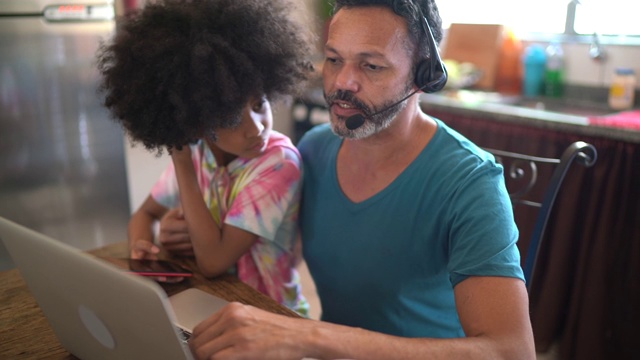 一个在家工作的男人，和他的女儿视频通话视频素材
