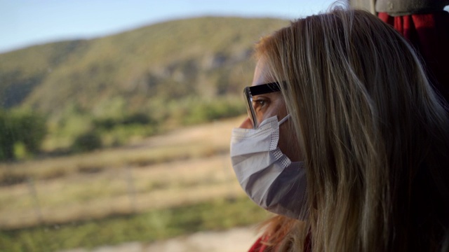 成熟的女性戴着防护口罩在巴士上传播冠状病毒的概念视频下载