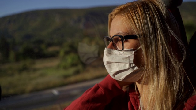 中年妇女戴着保护面罩看窗外的风景视频下载