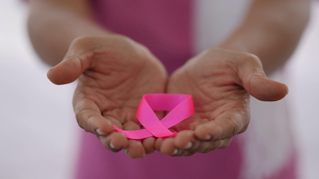 患者手持一条丝带，象征着乳腺癌患者视频下载