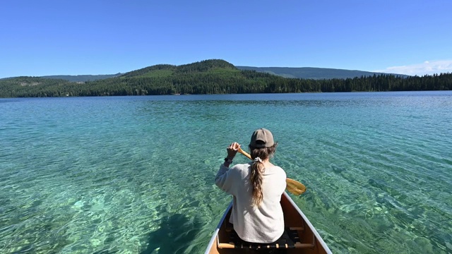 在美丽的山湖上划独木舟的女人视频下载