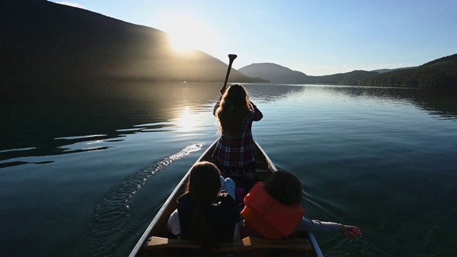 一家人在美丽的山湖上划独木舟视频素材