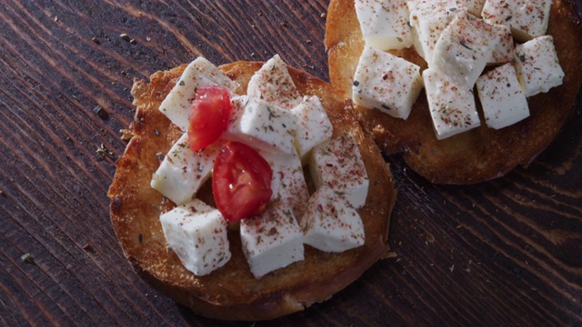 传统意式烤面包做准备。把番茄放在奶酪上。极端特写镜头。高角度视图视频下载
