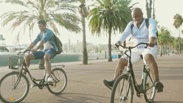 无忧无虑的父亲和成年的儿子在出租自行车上玩视频下载