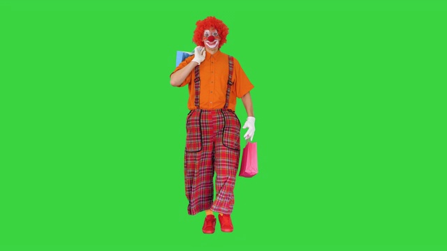 有趣的小丑走在购物袋的绿色屏幕，色度键视频素材
