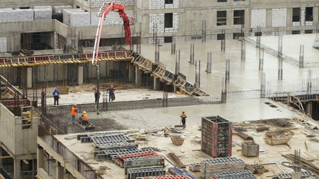 工人在大型建筑工地浇注和平整混凝土的时间间隔。先进的建筑技术和现代整体建筑。Сonstruction行业视频素材