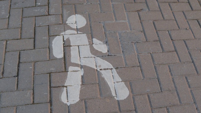 一个男人的身影在柏油路面上行走视频下载