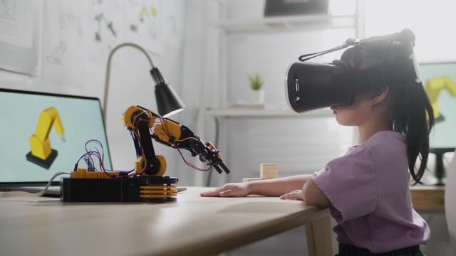 女孩戴着VR眼镜控制机器人手臂视频下载