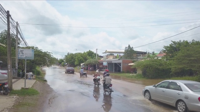 车辆和摩托车在大雨后穿过被水淹没的街道视频素材