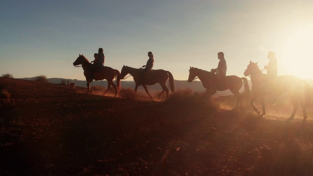 在夏季黄昏的纪念碑谷部落公园附近的沙漠里，纳瓦霍印第安人骑着他们的马视频下载