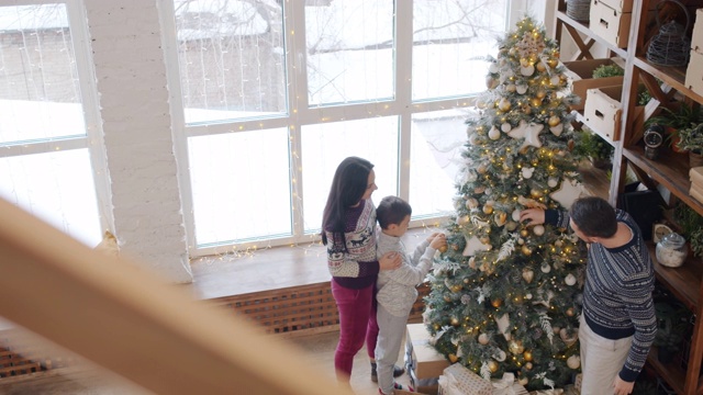 家长和孩子装饰新年树准备寒假的慢镜头视频素材