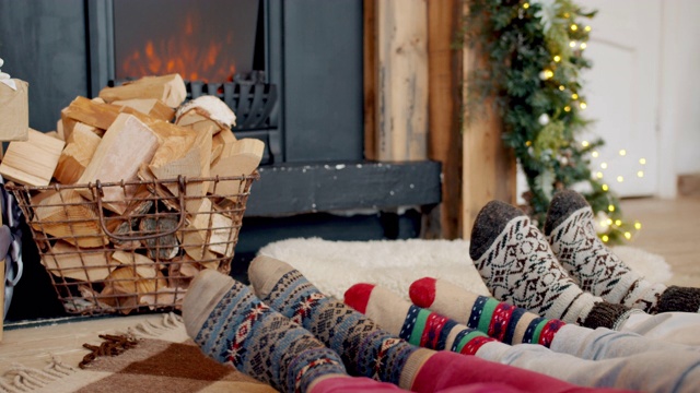 大的和小的脚在圣诞节风格的袜子移动与壁炉在背景的特写视频素材