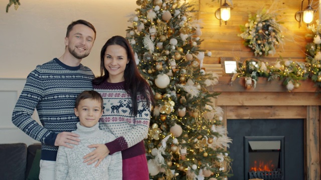 幸福家庭的肖像，父亲，母亲和孩子站在壁炉附近的圣诞节视频素材