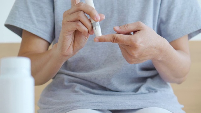 特写，年轻女性糖尿病患者正在做手指血糖水平测试。每日糖尿病护理视频素材