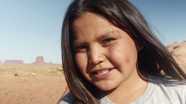 一个年轻的纳瓦霍男孩的肖像微笑和快乐的纪念碑山谷在他身后视频下载