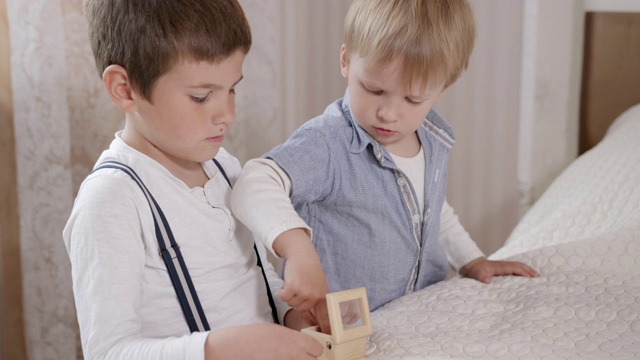 婴儿期，俊男小家伙们在床上房间玩游戏时一起玩旋律盒游戏视频下载