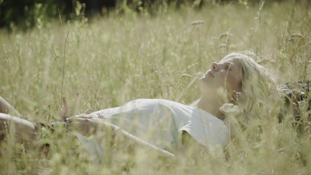 近距离的少女躺在草地上听无线耳机/ Tibble叉子，犹他州，美国视频素材