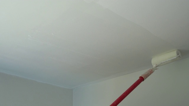 4k:用油漆滚筒在白色天花板上喷漆视频下载