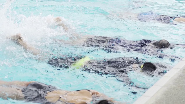 亚洲中国游泳运动员在游泳教练的指导下在泳池边练习腿溅水视频素材