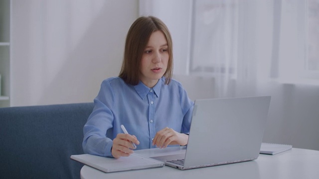 中年妇女正在用笔记本电脑进行在线视频通话，坐在家里，用现代通讯技术进行交流视频素材