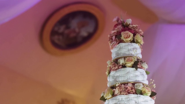 婚礼上用鲜花装饰的婚礼蛋糕。婚礼用的白蛋糕面包。节日甜点的概念视频素材