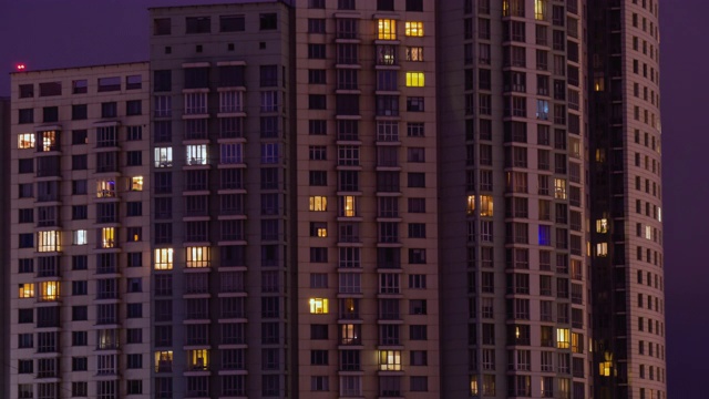 生活公寓大楼窗户在黄昏到夜晚的时间推移-正面的观点视频素材