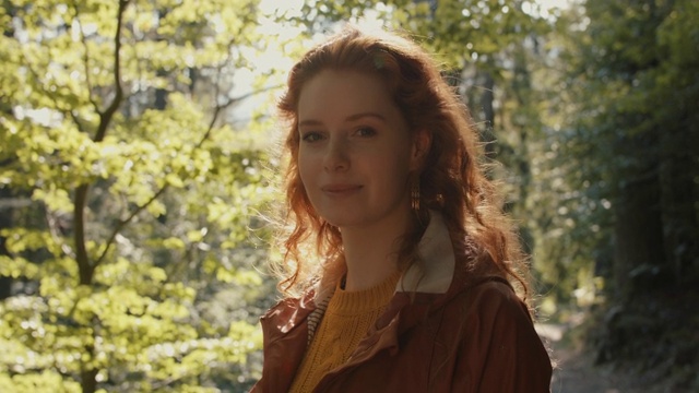 森林里有一头红色长发的女人微笑着视频素材