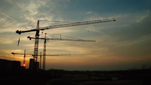 建筑工地-日落时起重机的鸟瞰图视频下载