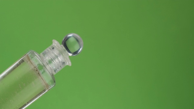 对角线旋转一瓶脸部化妆油。孤立的绿色。视频素材