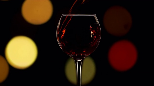 年轻的红酒为进杯慢动作圣诞灯散焦视频下载