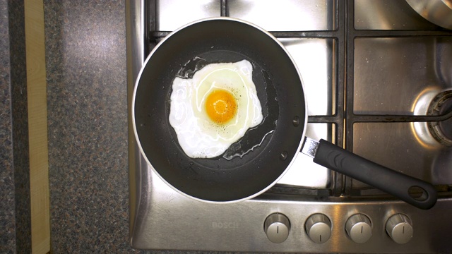 厨房炒鸡蛋和盐和胡椒被添加的俯视视图。视频素材