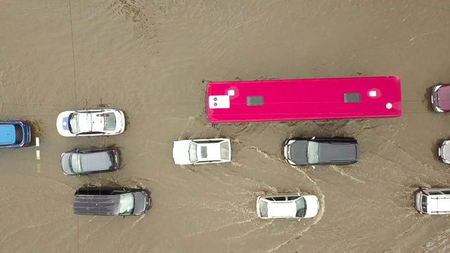 交通车辆在被雨水淹没的道路上行驶的鸟瞰图。视频素材