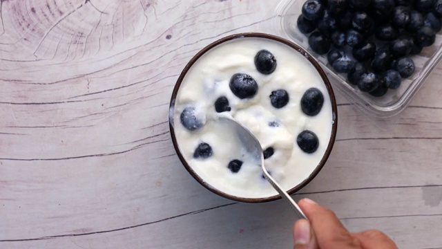 特写新鲜酸奶与蓝莓在一个碗视频下载