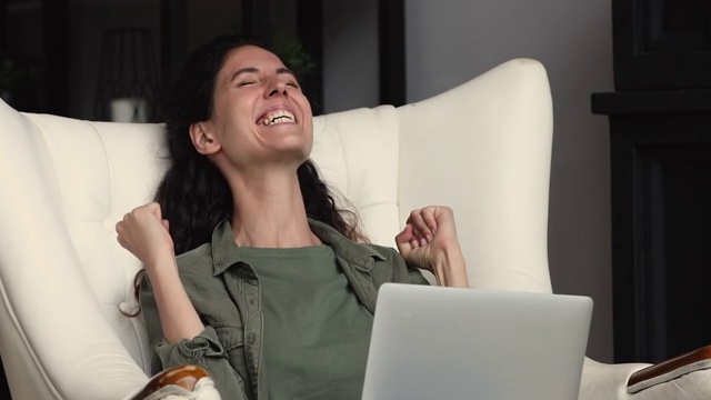 喜出望外的女人在笔记本电脑上读到好消息庆祝彩票中奖视频素材