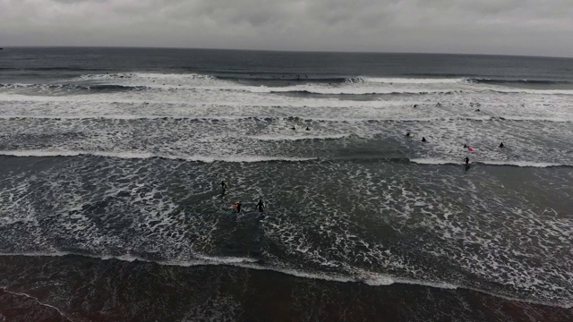 从海滩到海边的冲浪者在Fistral海滩-纽基康沃尔视频素材
