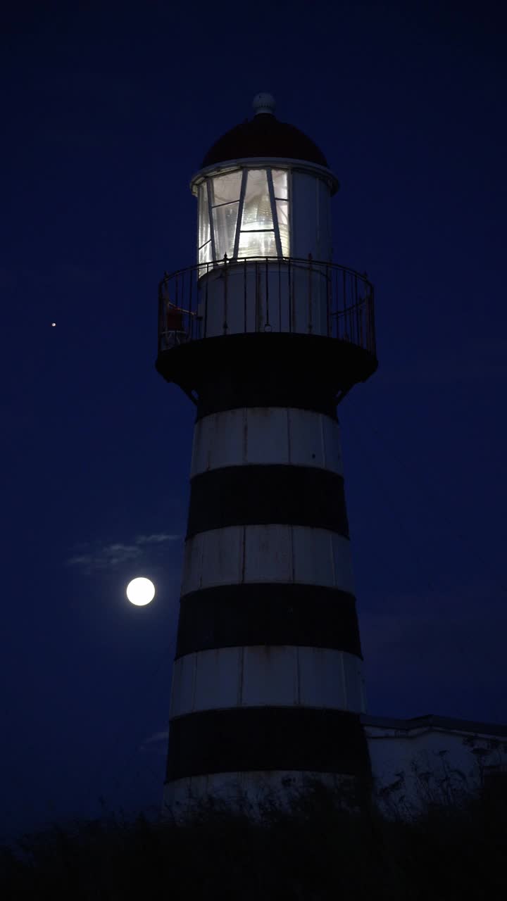 太平洋海岸的彼得罗巴甫洛夫斯基灯塔在夜晚发光。垂直格式视频视频下载