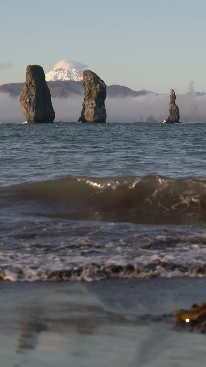 美丽的岩石峰岛在太平洋-三兄弟岩石的背景山脉太平洋海岸视频下载