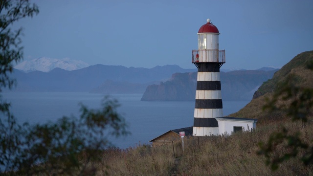 清晨黄昏发光的彼得罗巴甫洛夫斯基灯塔，位于太平洋阿瓦查湾岸边的堪察加半岛的玛雅奇尼角视频下载