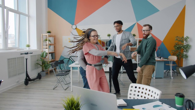 无忧无虑的办公室职员，女孩和男孩在工作场所跳舞，一起玩视频素材