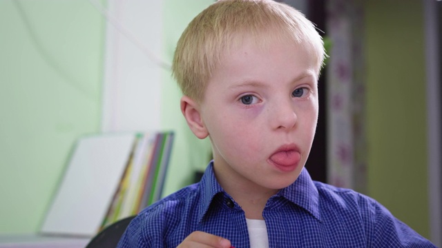 这是一幅患有唐氏综合症的残疾男孩在家里玩耍时的照片视频下载