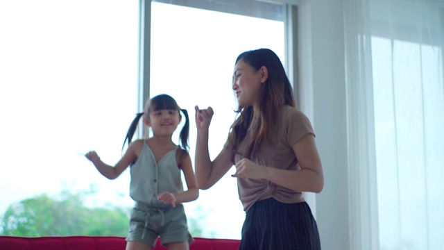 妈妈和她的小女儿一起在家里跳舞，慢动作。视频素材