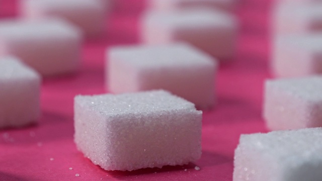 图案方糖在一个粉红色的背景，平移镜头，特写视频素材
