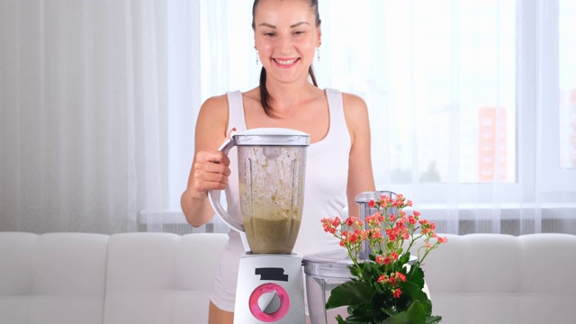 一个女人用搅拌器，做健康奶昔，排毒鸡尾酒的特写视频素材