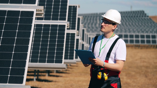 男工程师正在检查太阳能电池。可再生能源、太阳能发电厂、绿色电力概念。视频下载
